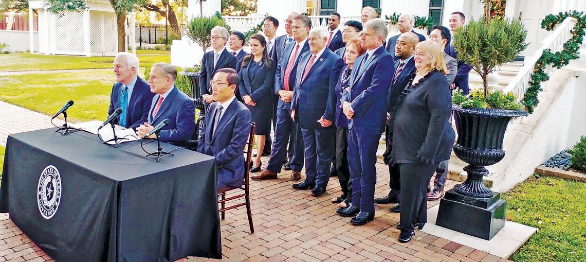 Gov. Greg Abbott (sitting, centered) begins a press conference to announce the Samsung investment in Taylor at the Governor’s Mansion in Austin Nov. 23, 2021. Photo by Jason Hennington