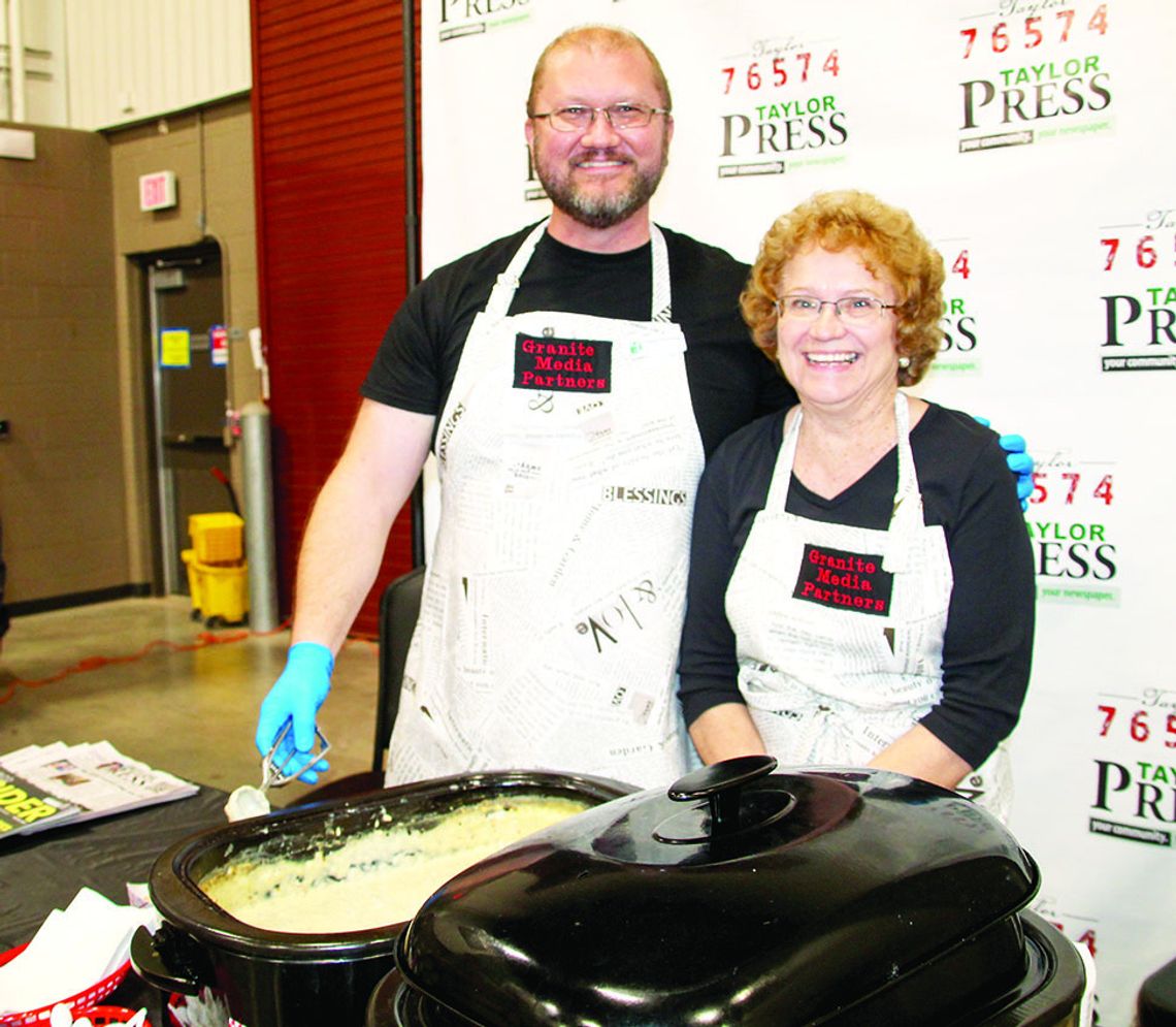 Granite Media Partner owner and CEO Daniel Philhower serves biscuits and gravy with mother-in-law Lynette Hunt during the ‘Food Dudes’ fundraiser to assist Taylor Independent School District classroom needs. Photo by Nicole Lessin