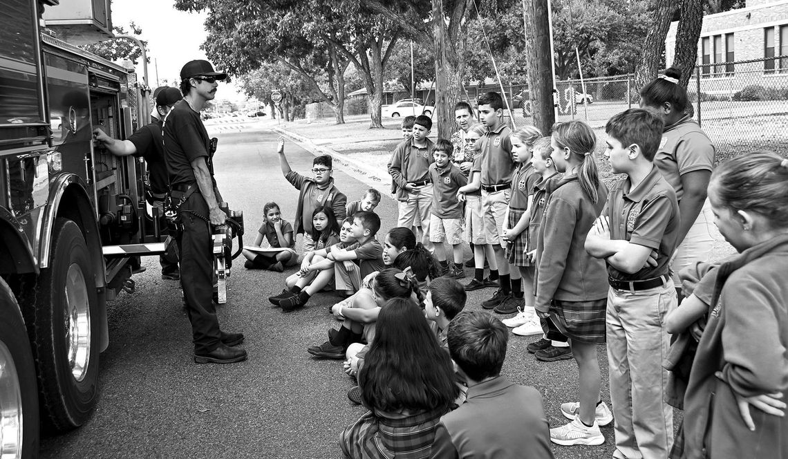 Firefighter Colton Brock shows students a tool that firefighters sometimes use during emergencies.