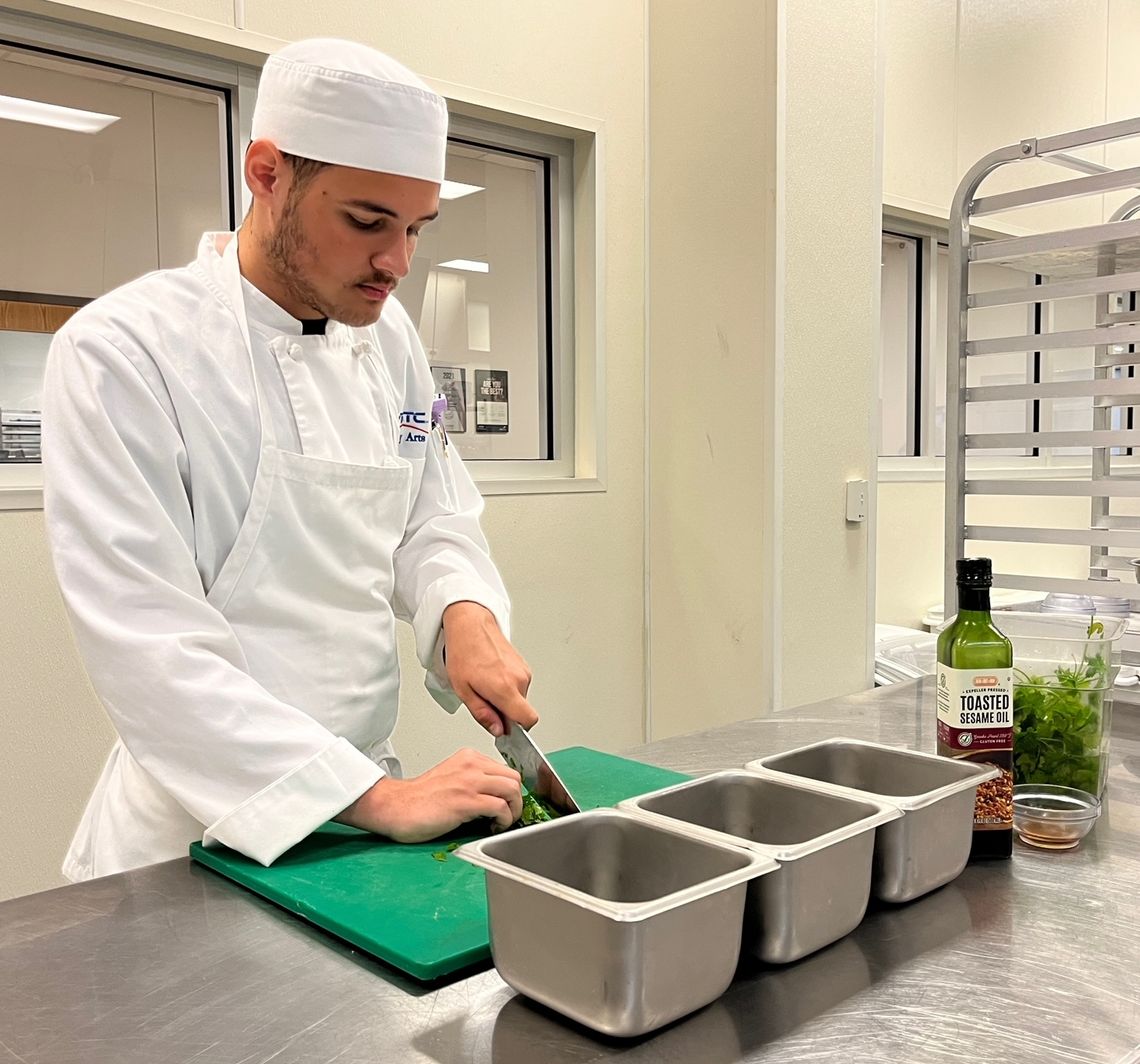 Student Jacob Johnson, of Pflugerville, chops parsley in a kitchen in Texas State Technical College’s Culinary Arts program at the East Williamson County campus.  