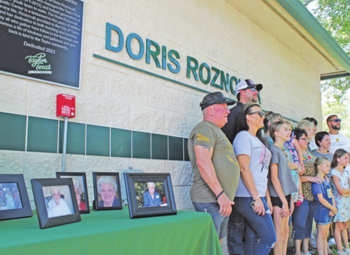 LEFT: The extended family of Doris Roznovak, shown in framed photographs on the table, celebrate the renaming of Murphy Park’s pool facility to the Doris Roznovak Aquatic Center in Taylor May 28.