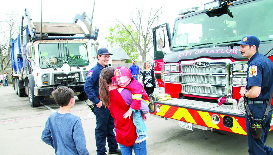 Declan Haussmann, 2, smiles after getting to see a ladder truck up close with mom Ashley Reynolds and big brother Stacy Davis, 11. Photos by Nicole Lessin