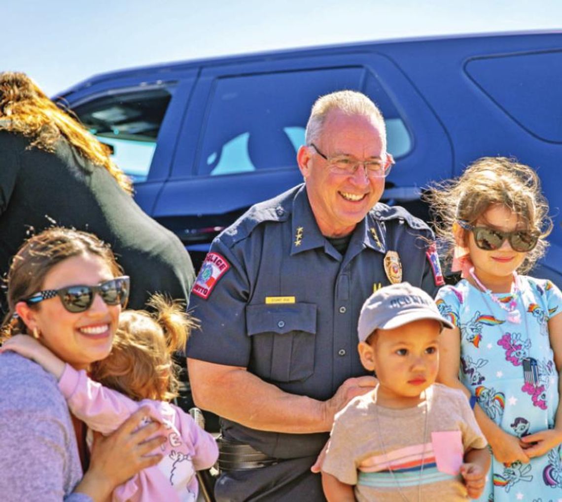 Hutto Police Chief James Stuart stops for photos with children who are between climbing in and out of vehicles.