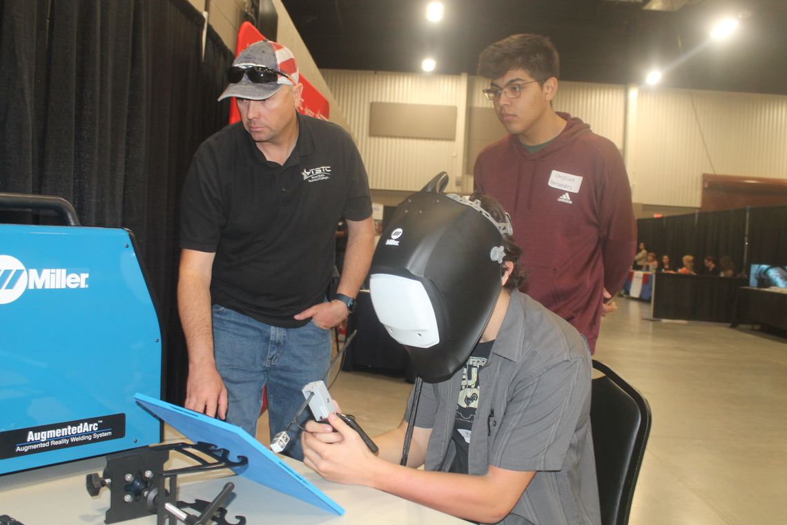 Robert Peller sits at the Texas State Technical College table alongside Christian Hernandez (right) and TSTC instructor Steven Coody at the Trades Day Career Fair at the Williamson County Expo Center in Taylor March 2. BELOW: A reverse view of the station is shown.