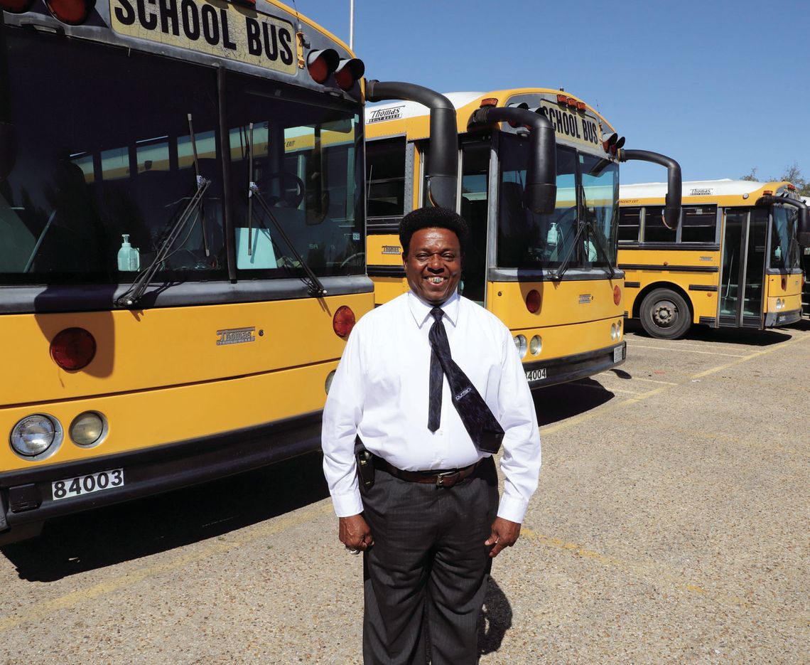 Taylor ISD Transportation Director, Carl Caldwell, is shown with four of the five older buses that will be replaced, thanks to a grant. Photo by Tim Crow