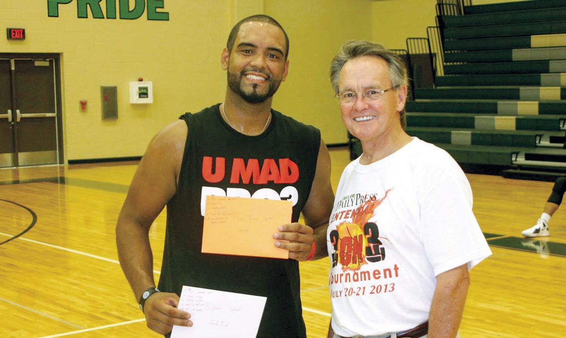 Adam Graves (left) was awarded his prizes by former Taylor Press Publisher Dennis Wade after winning both the three-point and free-throw contest on July 21, 2013, at the first-ever Taylor Press 3-on-3 Basketball Tournament. Photo by Jason Hennington