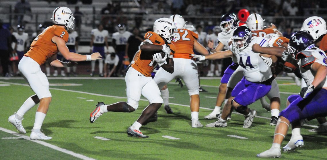 Hutto High School varsity football sophomore running back Keilan Chavies (17) takes a handoff from senior quarterback Will Hammond (2) on Aug. 25 during the Hippos’ 66-35 victory at home vs. San Marcos High School. Photo by Larry Pelchat