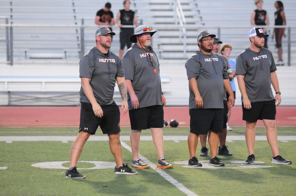 Hutto varsity football head coach Will Compton (second from the left) and his coaching staff look on during the Hippos' road scrimmage vs. Vandegrift. photo by Larry Pelchat P 