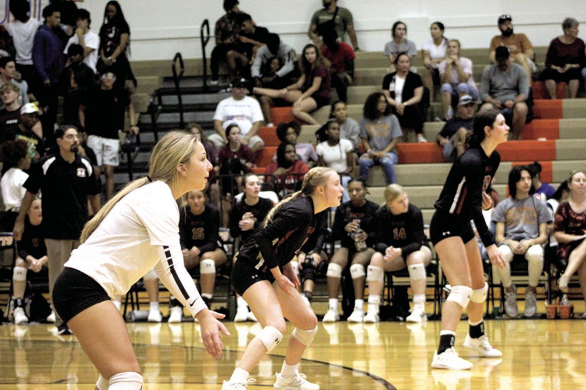 Hippos’ senior Adriana Gonzalez (left) gets in her defensive set along with Macie Atkinson (middle) and Isabella Orton. Photo by Evan Hale