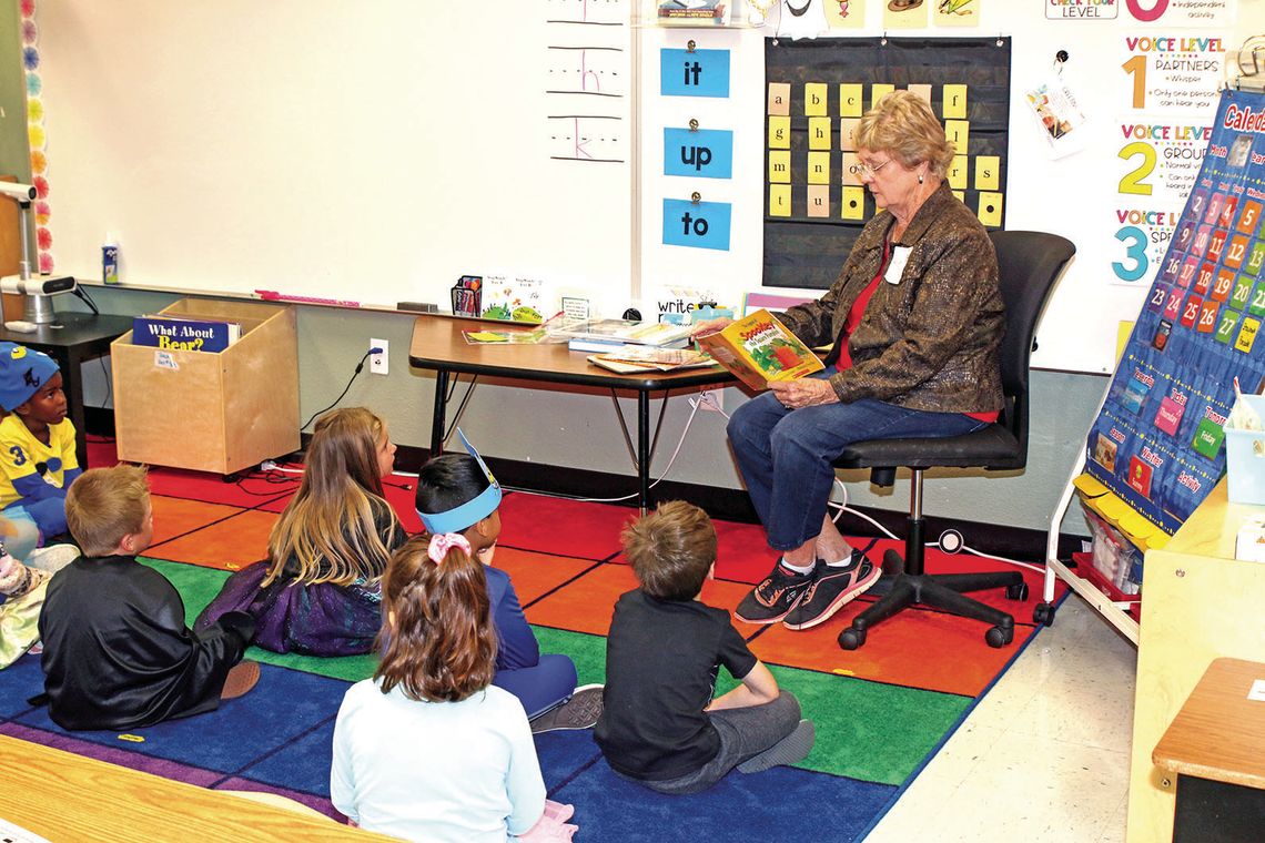 Retired Taylor teacher Kay Hortenstine reads a story to kindergarten students taught by her granddaughter, Lauren Hortenstine Jaecks. Hortenstine taught third grade for many years at T. H. Johnson Elementary and later at Pasemann. Photo by Tim Crow