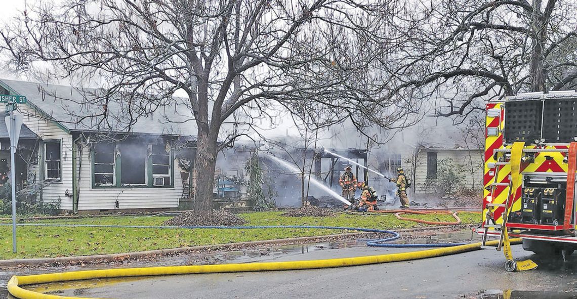 Firefighters extinguish a house fire Dec. 19 at the corner of Fisher and Kimbro Streets. Photo by Jason Hennington