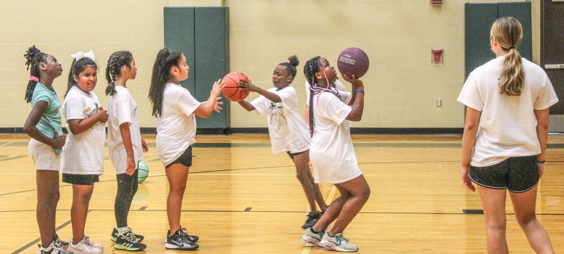 A group of young campers waits in line while playing a game of knockout on June 8 during the Lady Ducks Youth Basketball Camp.