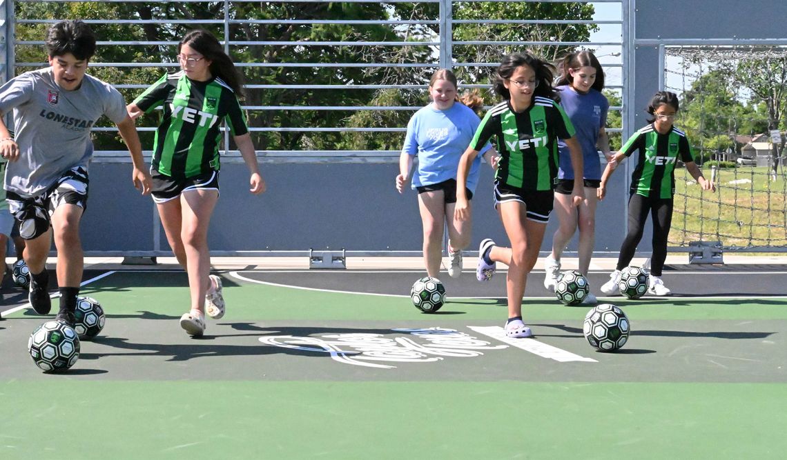 Children kick off use of the new soccer mini-pitch Saturday morning. The court can be used for individual and pickup soccer games. Photos by Kendra Maness