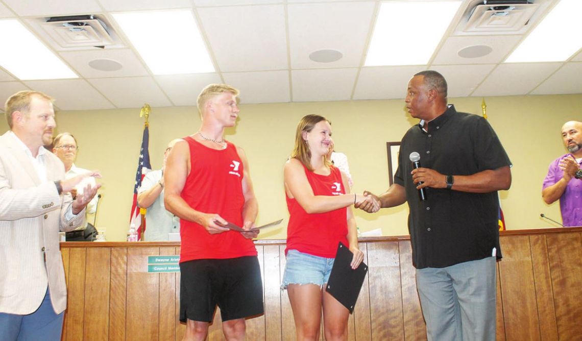 Mayor Gerald Anderson shakes lifeguard Sydney Branson’s hand prior to doing the same with Landon Mikulencak as Taylor parks and recreation director Tyler Bybee (far left) and the Taylor City Council look on during a meeting at city hall in Taylor June 23. Photo by Fernando Castro