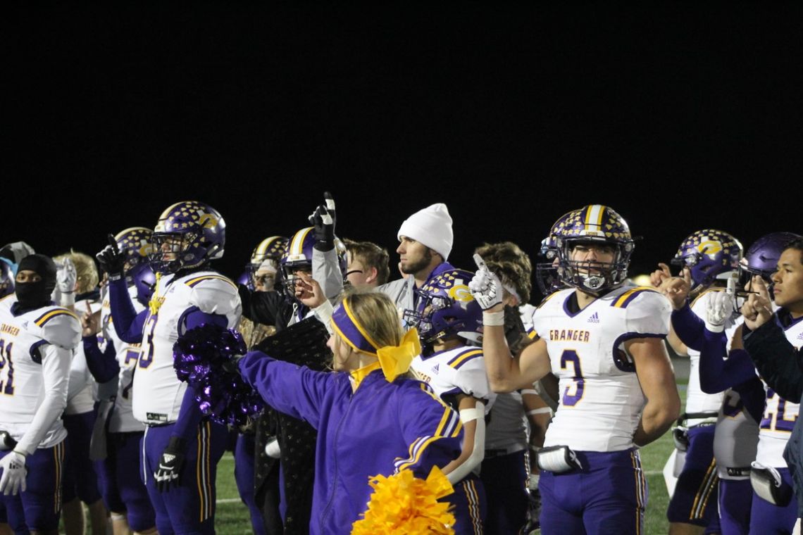 Granger Lions salute the crowd while listening to their school song after winning the bi-district championship.