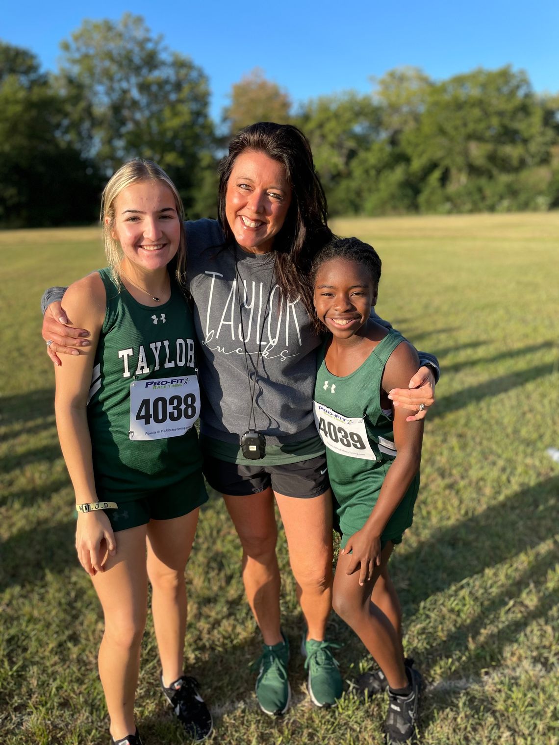 Coach Shelli Cobb stopping to take a picture with Lily Vega (left) and Zari Thompson after a cross country meet earlier this season.      Courtesy Photo    