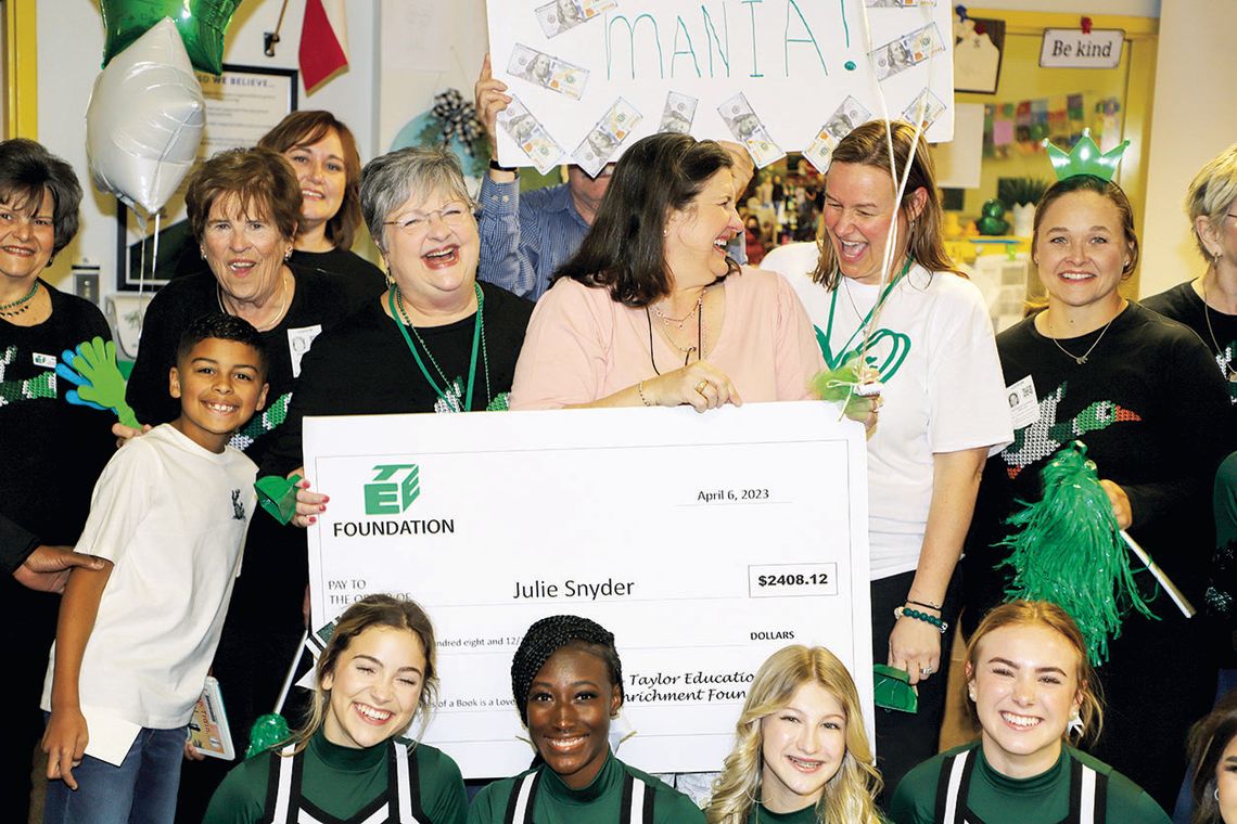 Naomi Pasemann Elementary librarian Julie Snyder is congratulated by TEE Foundation Executive Director Anita Volek and NPE Principal Cynthia Proctor as TEE Foundation board members and THS cheerleaders join the celebration. Photos by Tim Crow