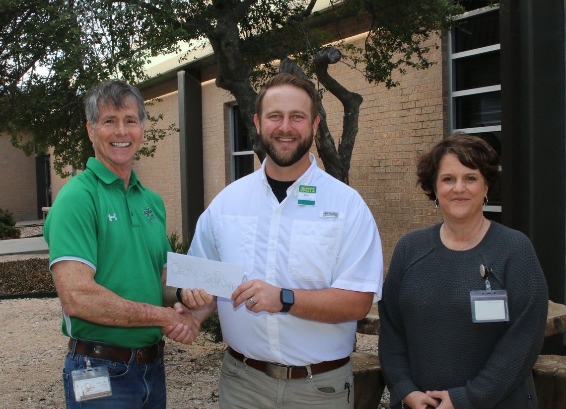 Tyler Volek, manager of McCoy’s Building Supply in Taylor, presents a check for $2,000 to John Matthews, Taylor ISD Family Support Services coordinator. This donation will help provide a variety of programs and services for Taylor families. Photo by Tim Crow