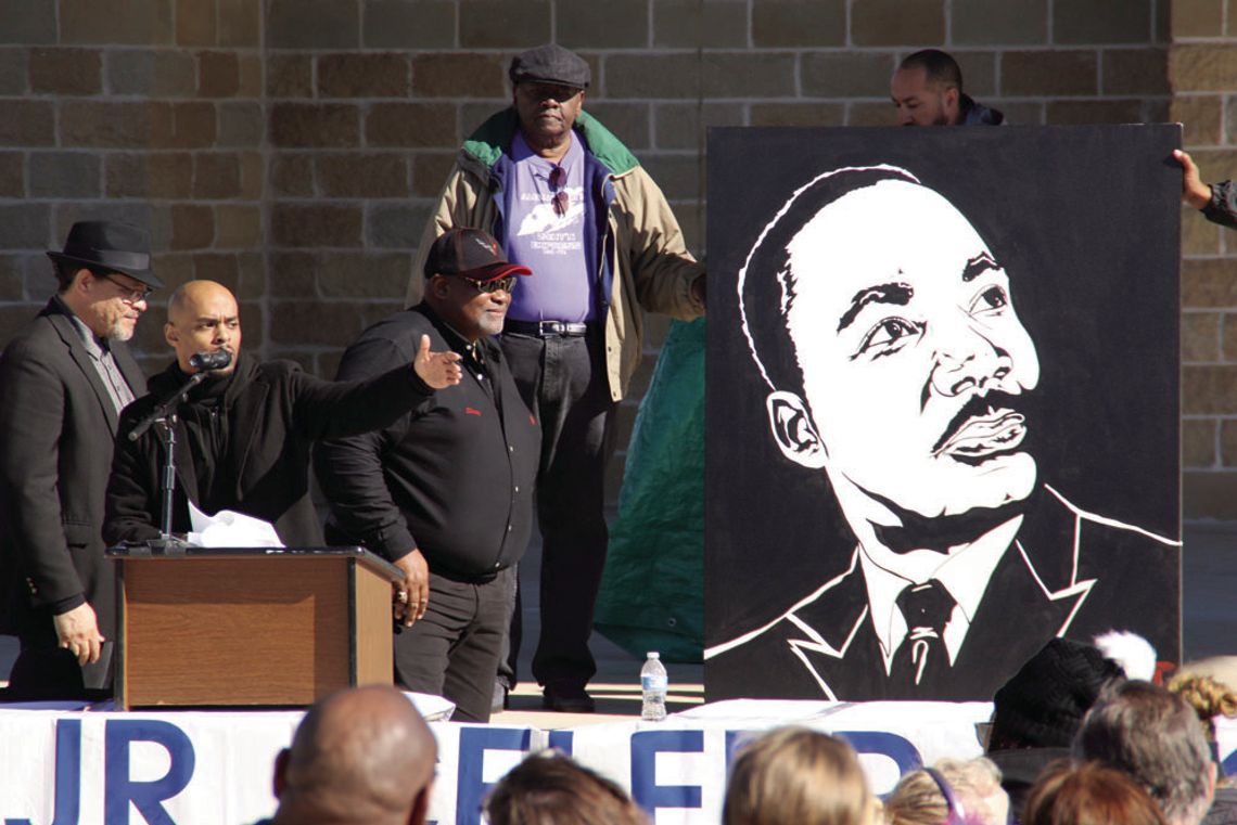 Stephen Michael Johnson (center) talks about the significance of Dr. Martin Luther King Jr. as his painting is unveiled by (from left) Rev. Anthony Watson, Shorty Mitchell and Nelson Alexander. Photos by Jason Hennington