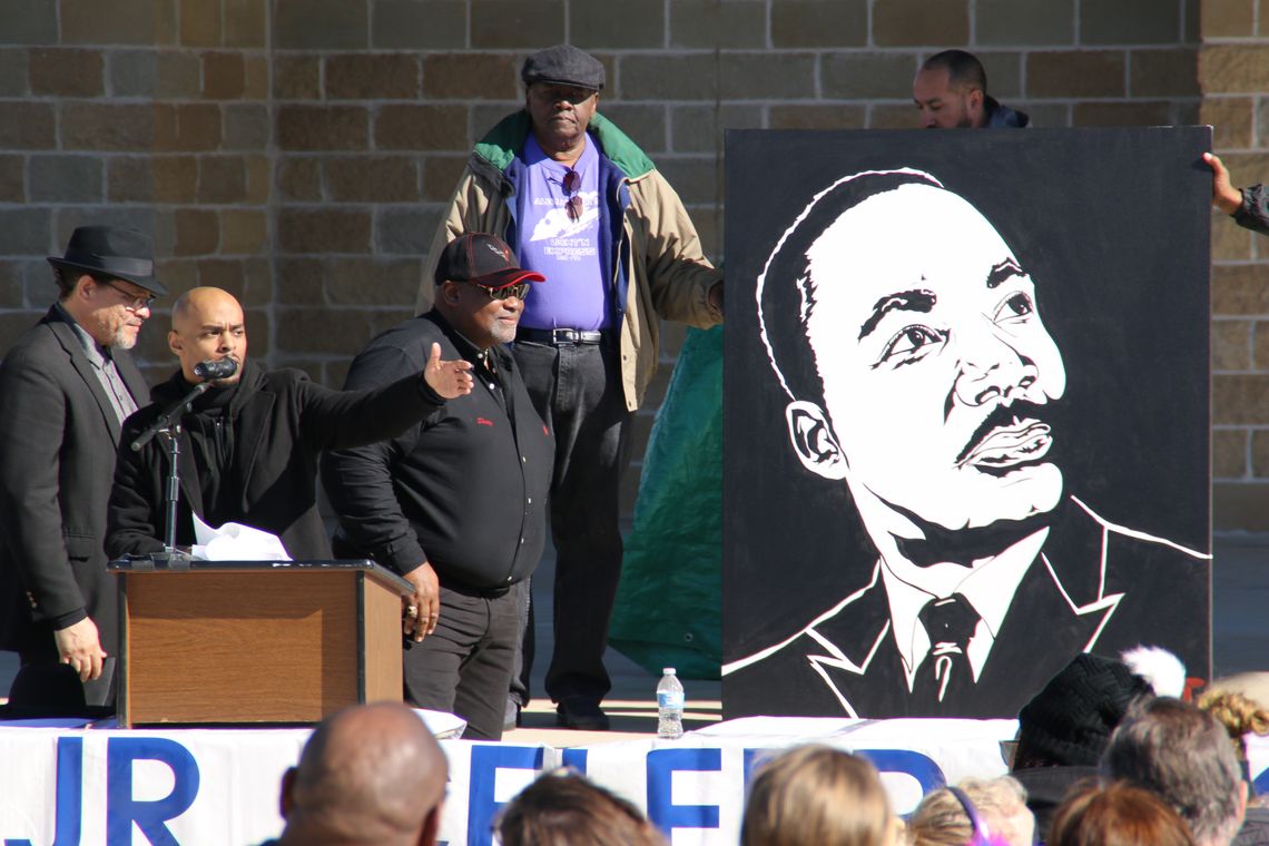 Stephen Michael Johnson (center) talks about the significance of Dr. Martin Luther King Jr. as his painting is unveiled by (from left) Rev. Anthony Watson, Shorty Mitchell and Nelson Alexander. Photo by Jason Hennington