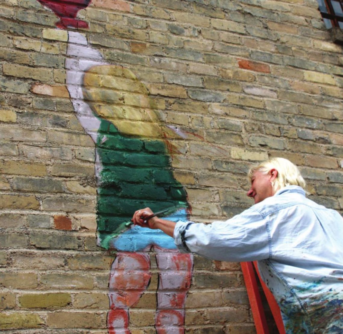 Judy Blundell paints a little girl holding on to a red balloon in Potter’s Alley. Photo by Jason Hennington