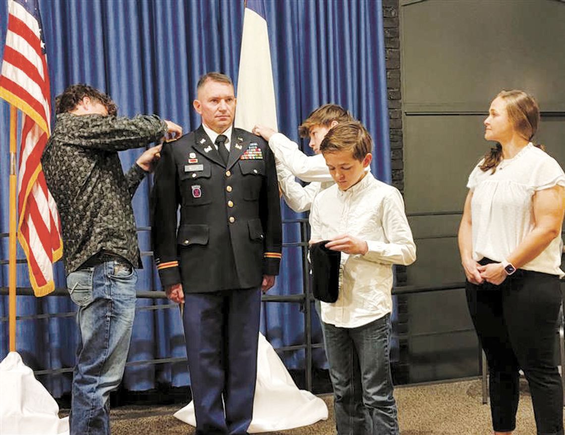 Sons Jackson Meller (left) and Joshua Meller attach shoulder boards displaying Joseph Meller’s new rank as an Army lieutenant colonel; youngest son John Meller pins his dad’s beret Feb. 8 during the promotion ceremony at Camp Mabry as wife Rhonda Meller looks on. The family calls Taylor ho...