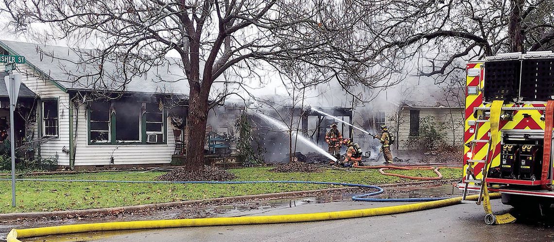 Firefighters extinguish a house fire Monday afternoon at Fisher and Kimbro streets. Photo by Jason Hennington