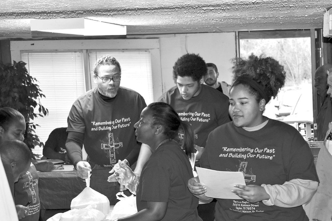 Pastor Anthony Watson helps members prepare Thanksgiving dinners at The First Baptist Church. Watson will celebrate 25 years, the longest tenure for a pastor at the church, Sunday, July 23 during the 10:45 a.m. service. Courtesy photo