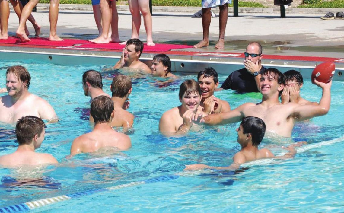 Thrall ISD players and coaches beat the heat by tossing the ball around in Murphy Park pool in Taylor in this August 2015 photo. File photo