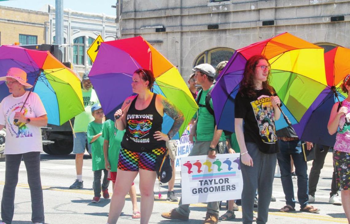 The Parasol Patrol and others listen to Mayor Brandt Rydell’s opening remarks at the Taylor PRIDE Festival in Taylor June 25. Photo by Fernando Castro