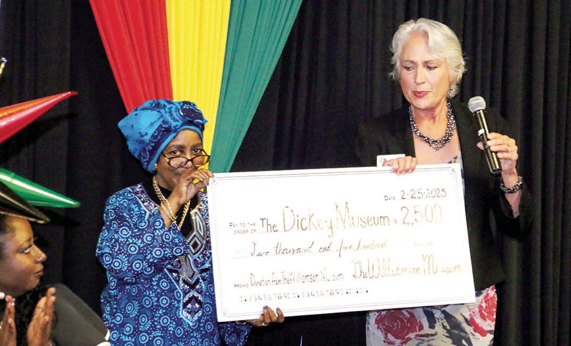 Dickey Museum Board President Jennifer Harris (left) accepts a $2,500 check from Nancy Hill of the Williamson Museum for the restoration of the Dickey Museum &amp; Multipurpose Center. Photo by Jason Hennington