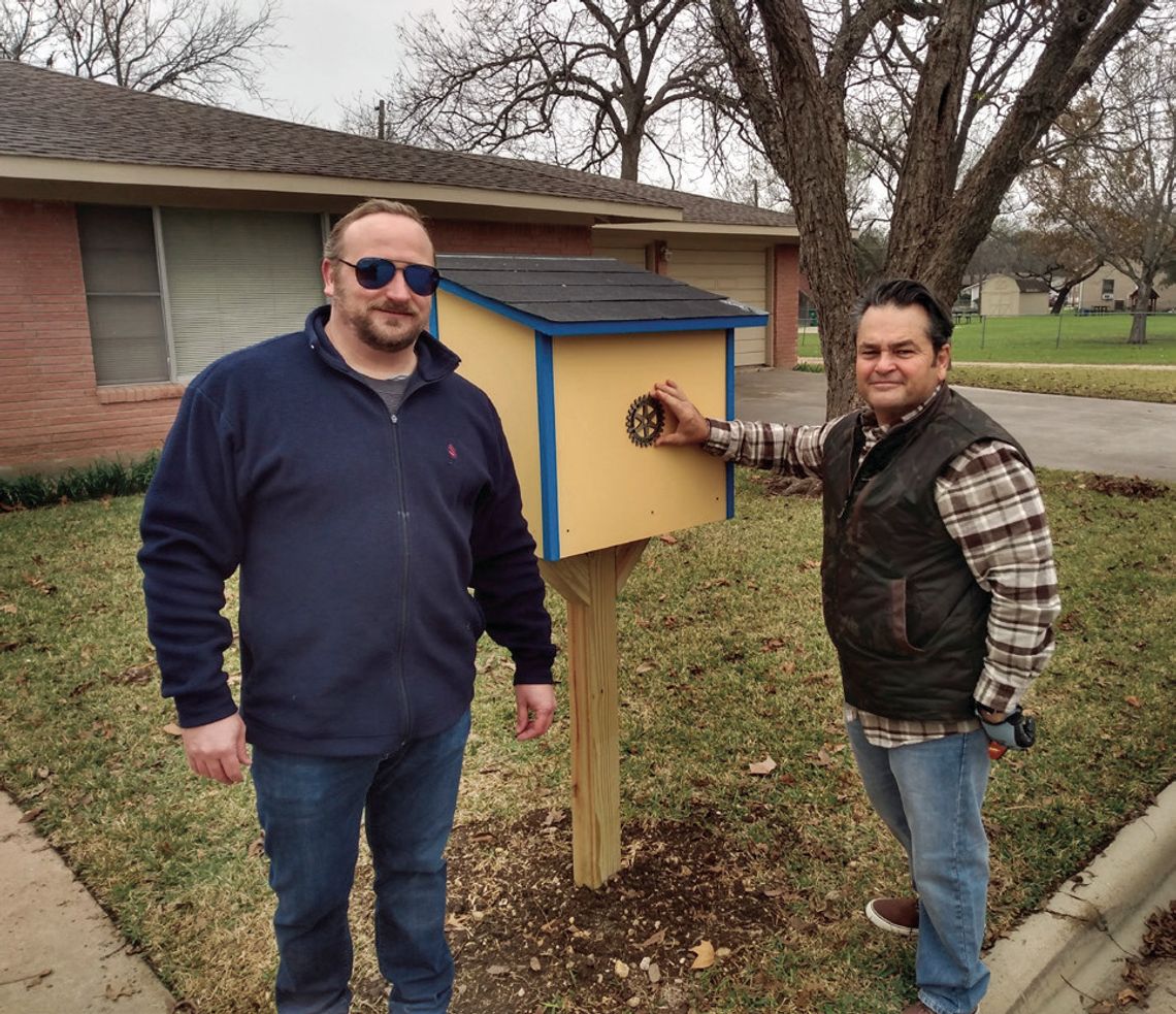 Rotary club members Ryan Stiba and Jim Buzan pose next to the new Little Free Library they helped install Dec. 16 in front of the church offices on Seventh Street in Taylor.