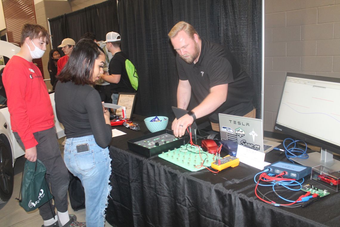 Brandon States talks with students at the Tesla table at the Greater Taylor Chamber of Commerce Trades Day career fair at the Williamson County Expo Center in Taylor March 2.