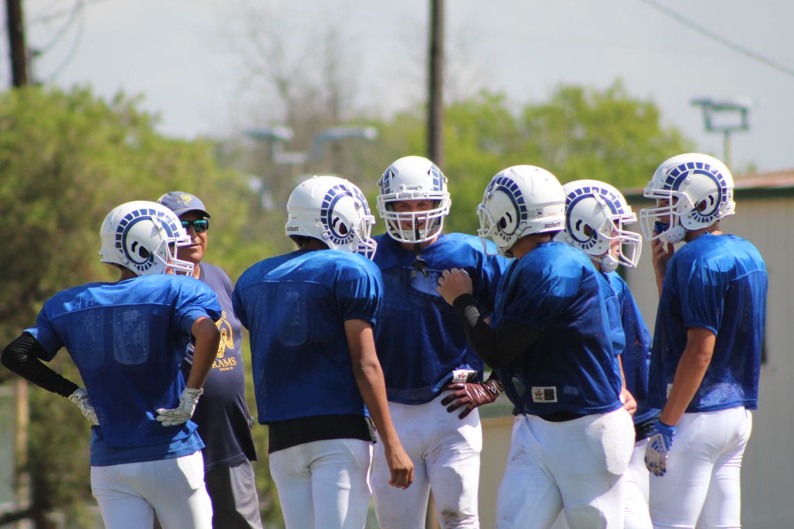 St. Mary's Catholic School varsity football huddles around coach Rick Cobia during a 2022 preseason scrimmage. Photos by Evan Hale