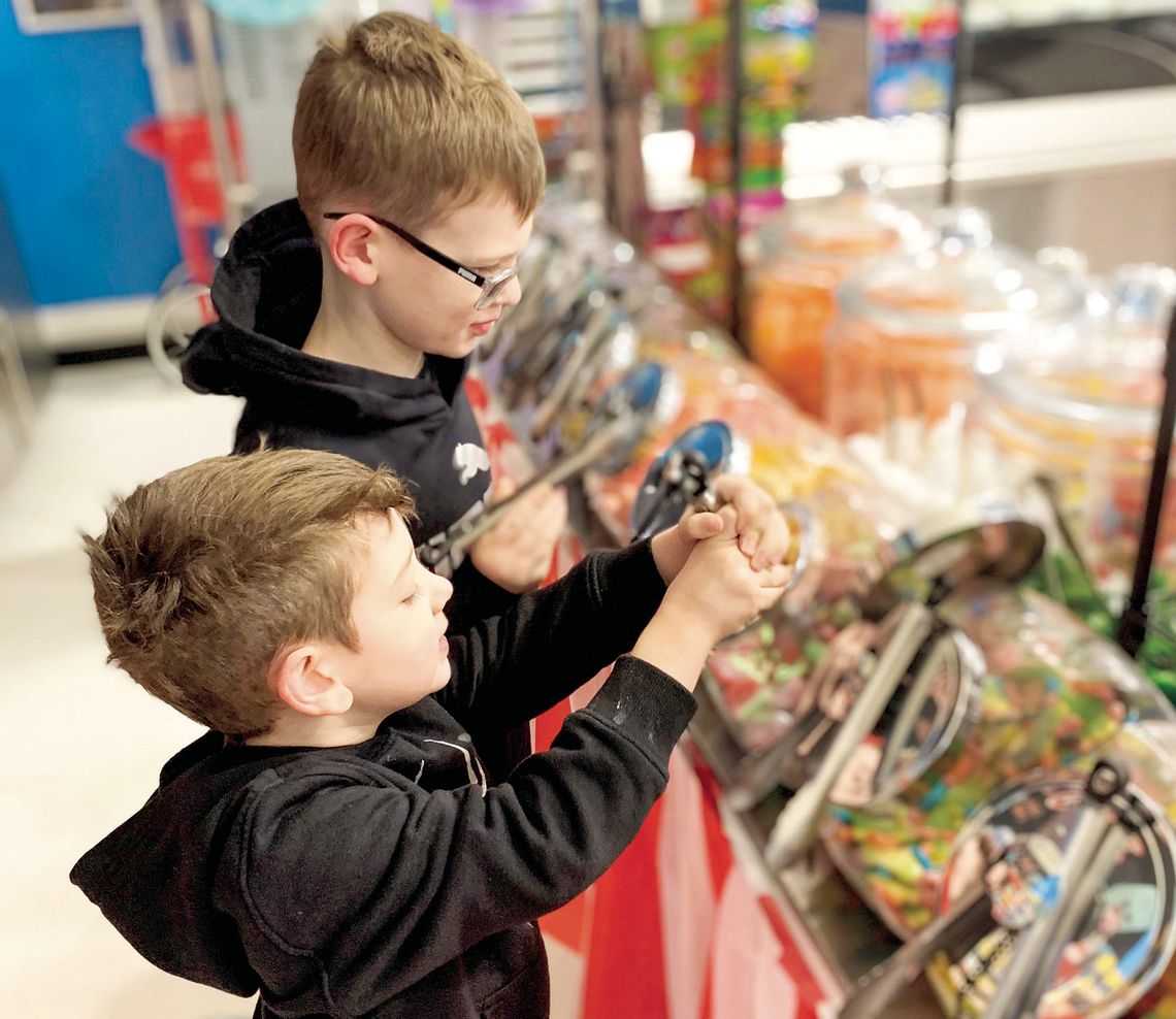 Olin Petke Jr., 9, and Ostin Petke, 4, gather candy at their father’s store Jan. 30. Fudge in the shape of Texas (top left) are on display at Big O’s Classic Candy and Nitrogen Ice Cream. A batch of heart-shaped candies (top right) filled with Heath Bars and peanut butter await Valentine’s...