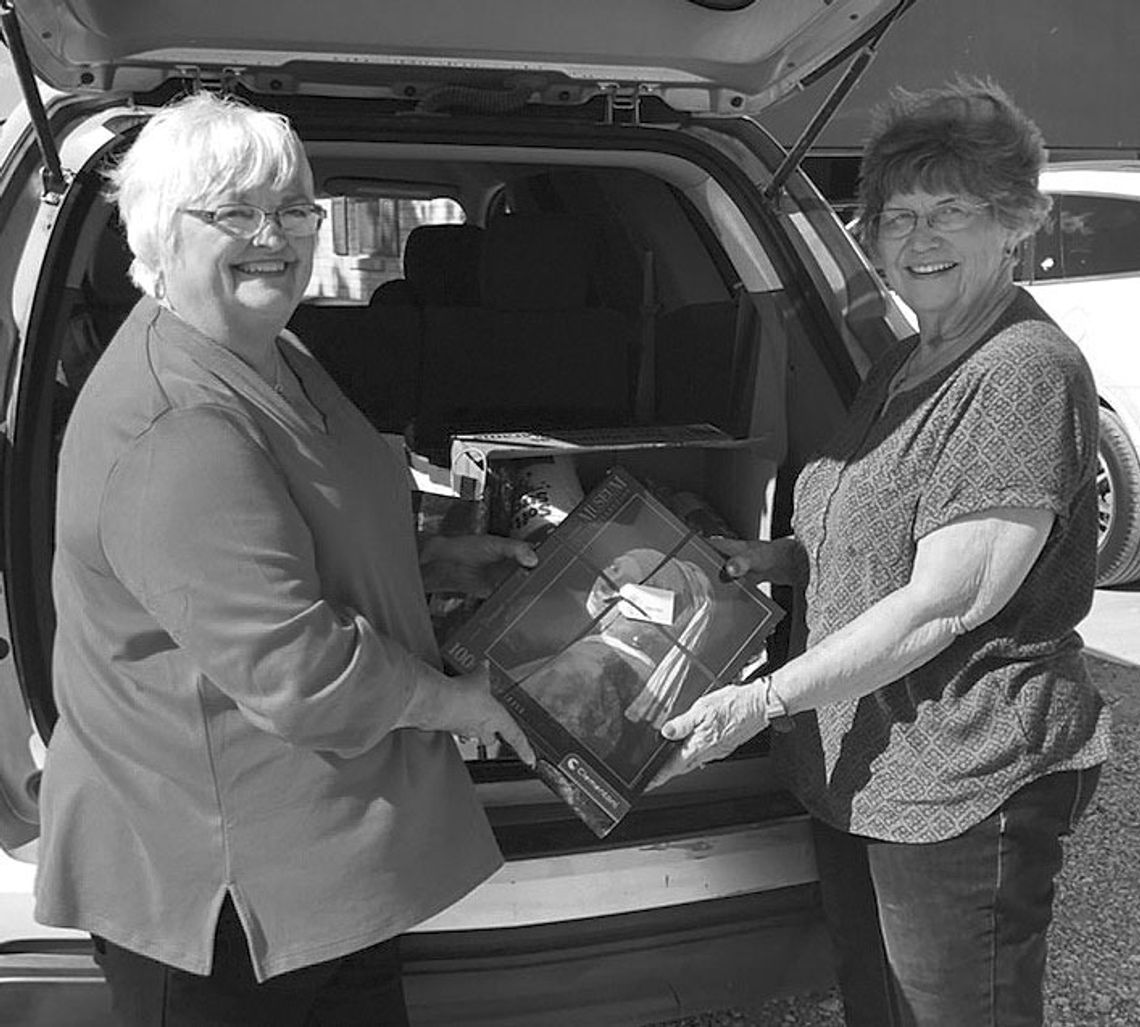 Taylor Area Businesswomen President Charlotte Albert unloads Bingo gifts to Senior Citizens Coordinator Dorothy Fischer.