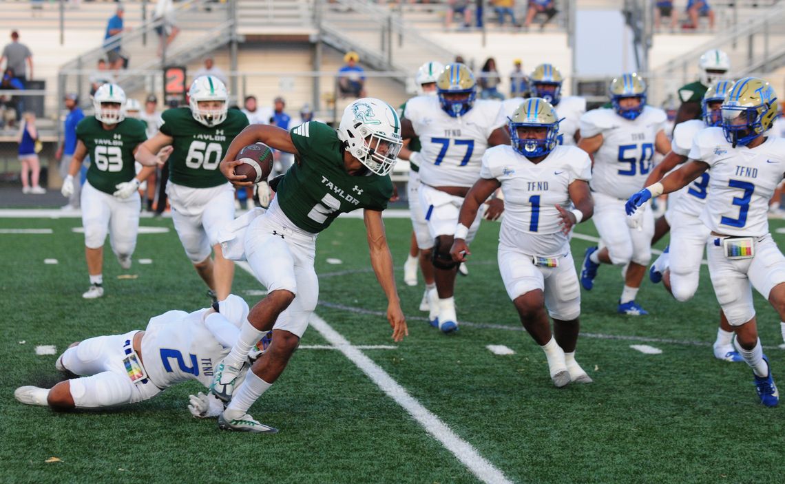 Taylor High School junior running back Andrias breaks a tackle and gains yardage on Friday night during the Ducks’ 39-6 rout of Rockdale High School at The Duck Pond. Photo by Larry Pelchat 