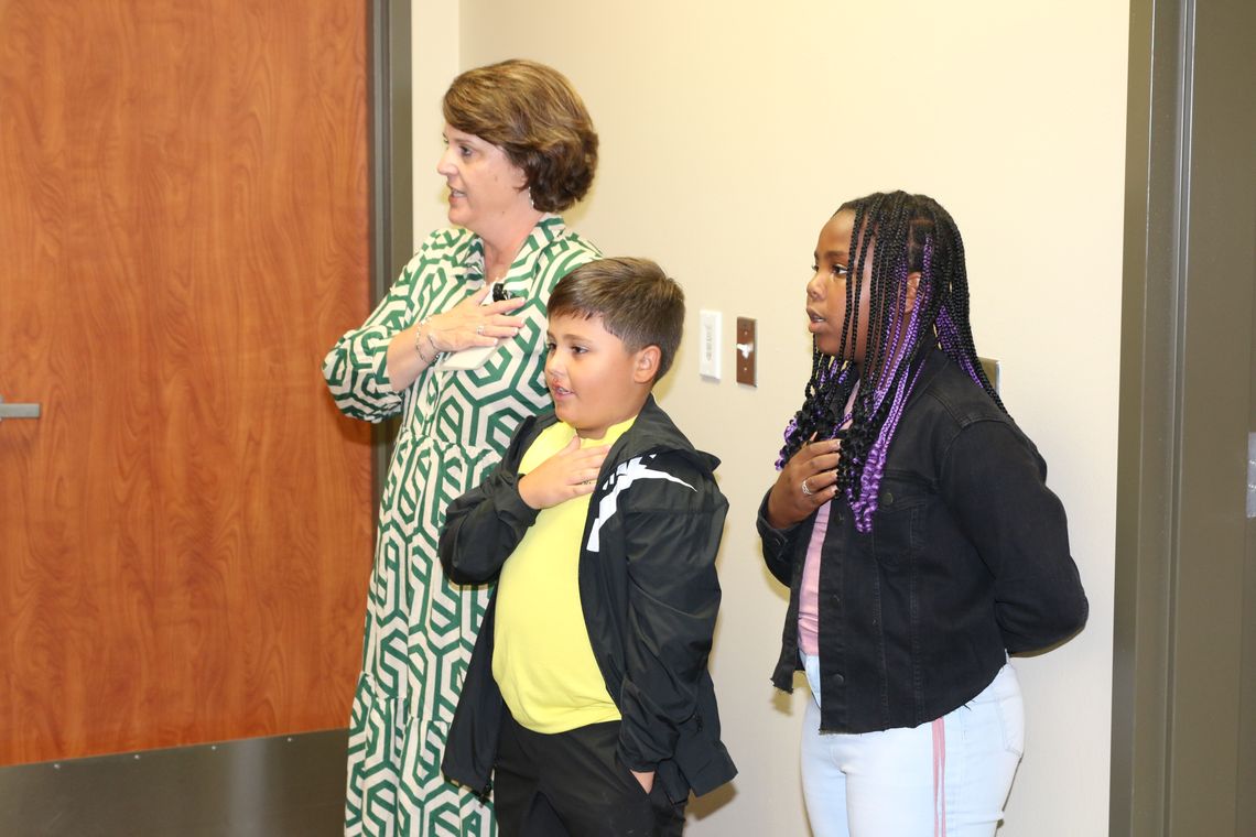 Pledge Leaders Paxton Valdez and C’Anne Adelle Campise, students at Naomi Pasemann Elementary School, open the October Taylor school board meeting by leading the pledge of allegiance. Accompanying them is Jennifer Patschke, Executive Director of Elementary Schools and Special Programs.