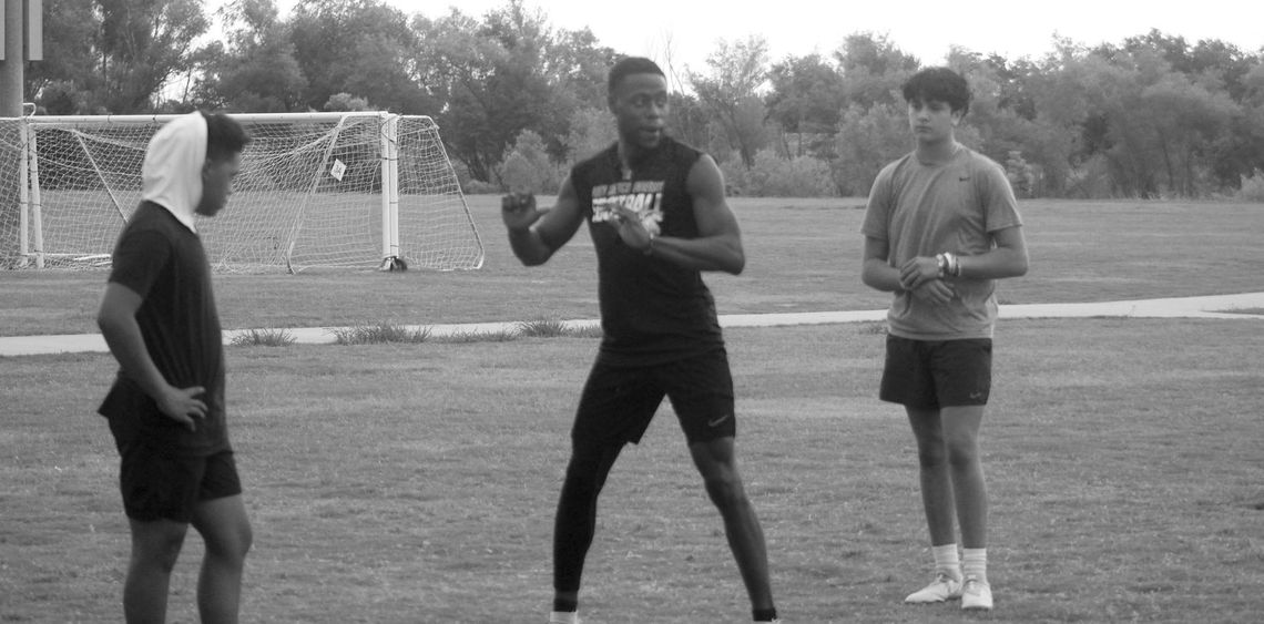 Terrell Reynolds explains an exercise focused on quarterback footwork on Monday, June 19 at the Taylor Athletic Complex. Photo by Andrew Salmi