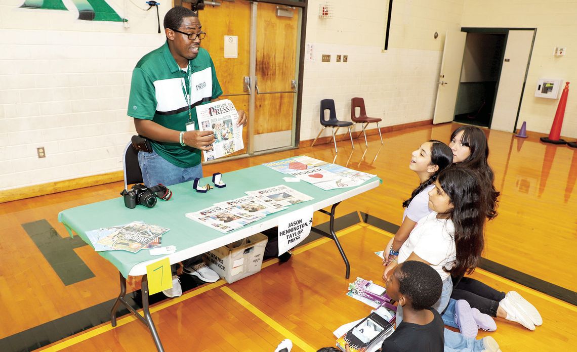 Students learn more about the Taylor Press and what it takes to produce a newspaper from Area Editor Jason Hennington during Career Day at Main Street Intermediate. Photo by Tim Crow