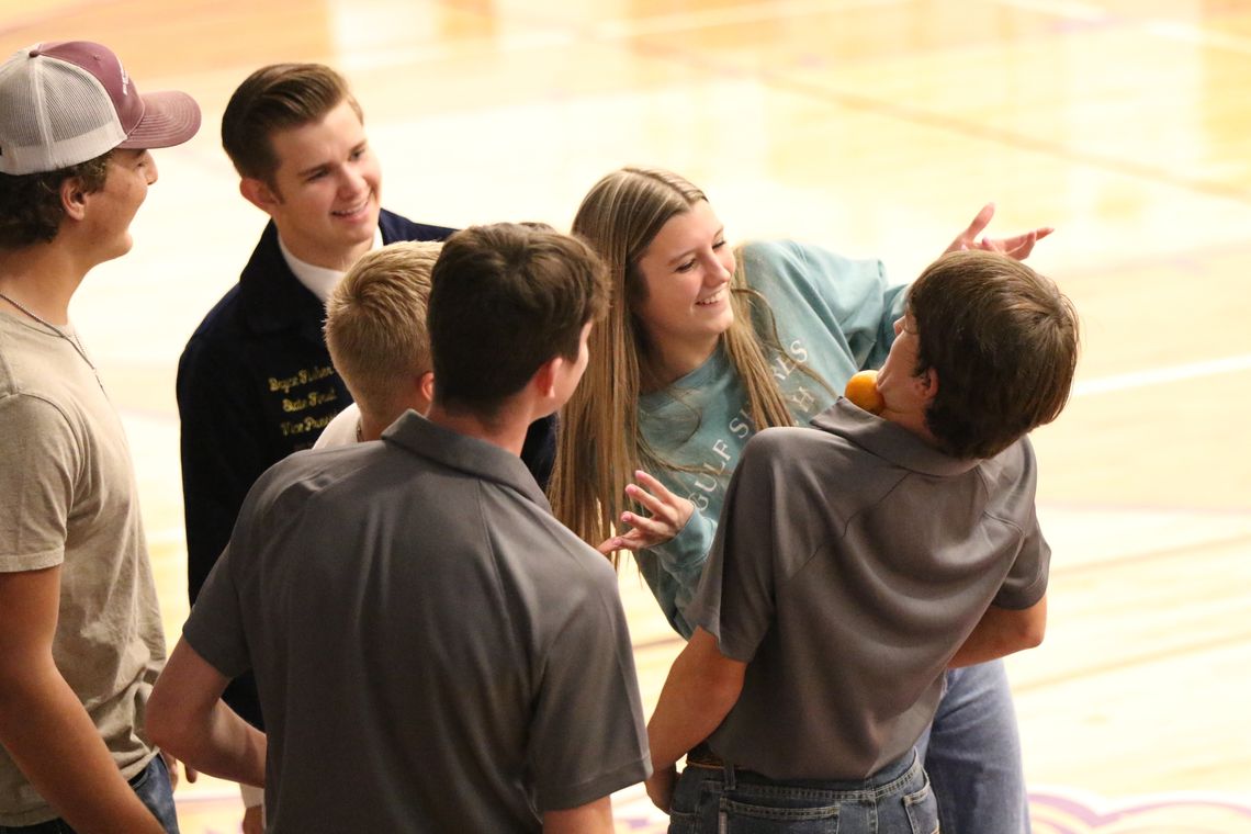 Thrall FFA Vice President Ty Bradford, 10th, attempts to pass an orange to Stephanie Widner, 10th, without using his hands as State FFA officer Bryce Fisher and FFA members Dawson Meiske, Maverick McAllister, and Anson Gonzales cheer them on.