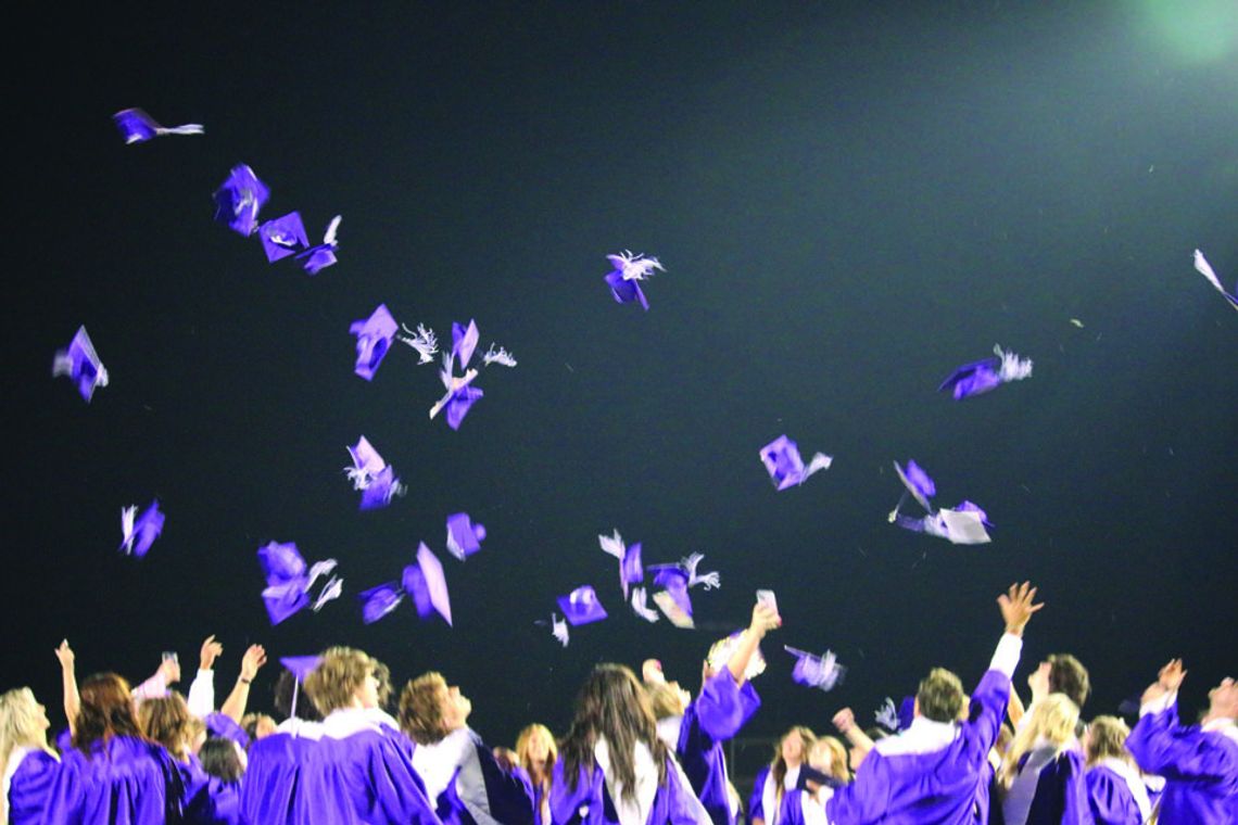 Graduates toss their caps after the ceremony. Photo by Edie Zuvanich