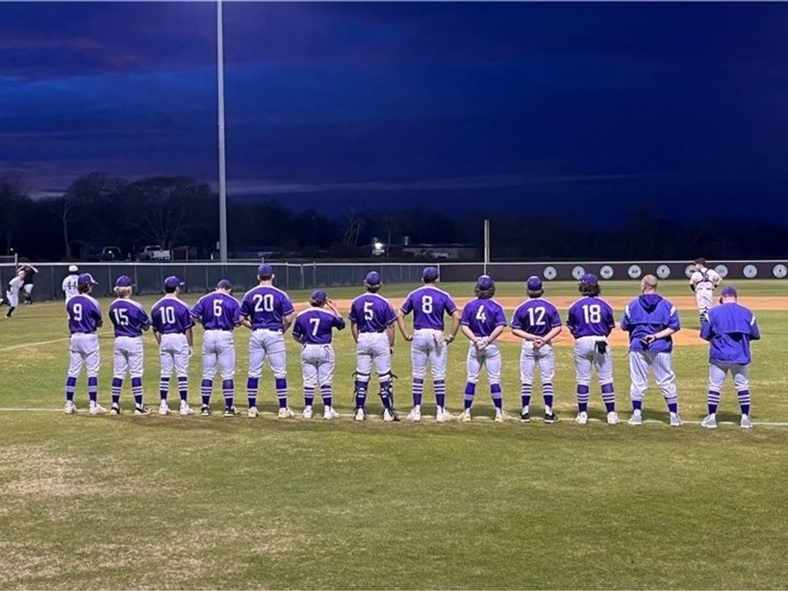 Thrall Tigers varsity baseball team standing shoulder to shoulder as the National Anthem plays before their first game of the season.