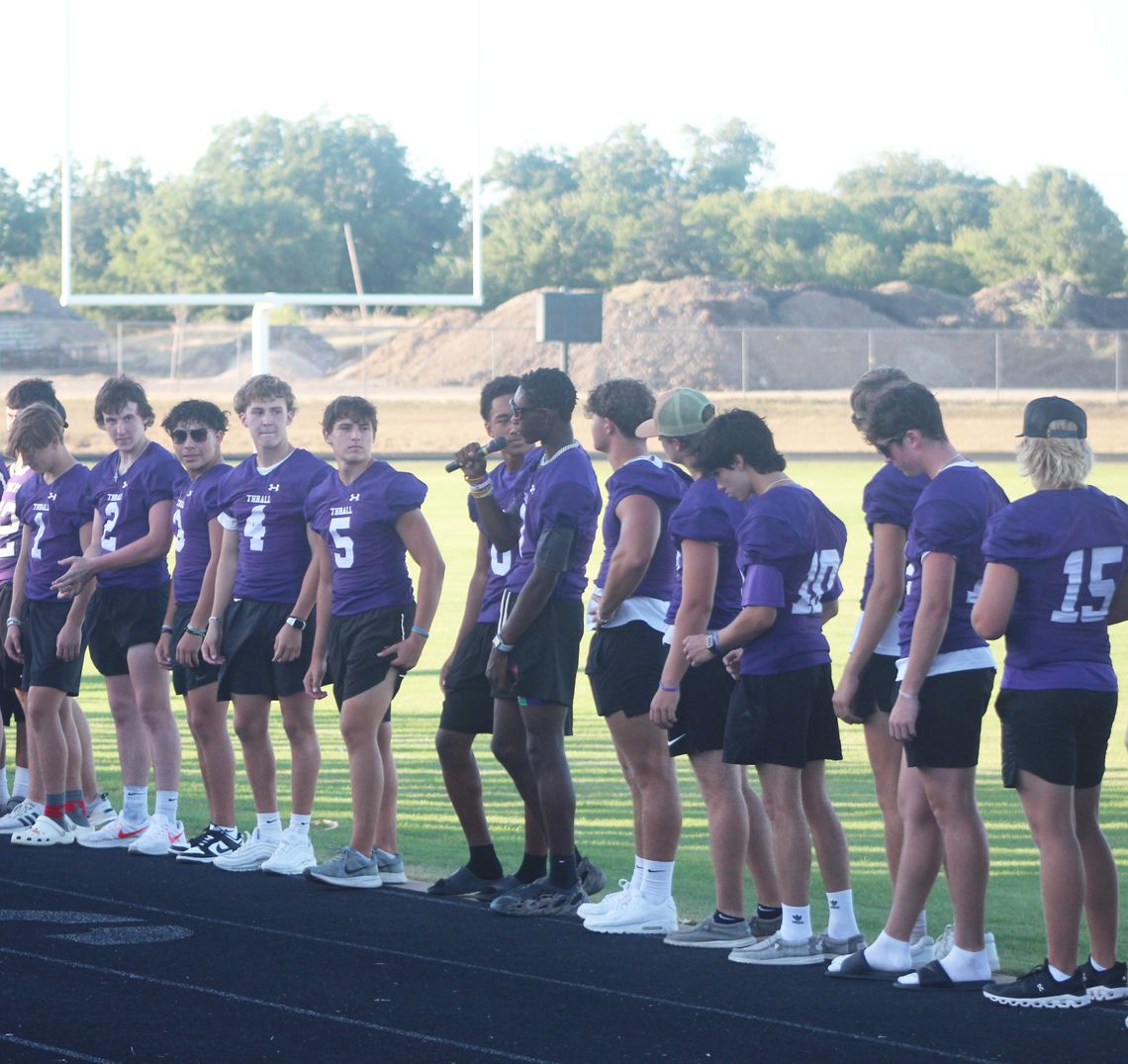 Thrall High School varsity football senior, Steven Walker  (center) introduces himself and his team 