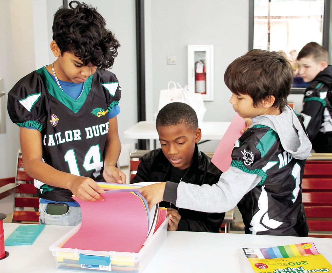 (From left) Dimitri Burt, 10, gathers supplies Dec. 20 with Clavon Barnes, 10, and Davian Meadows, 10 at Taylor CAARTS Station. Photos by Nicole Lessin