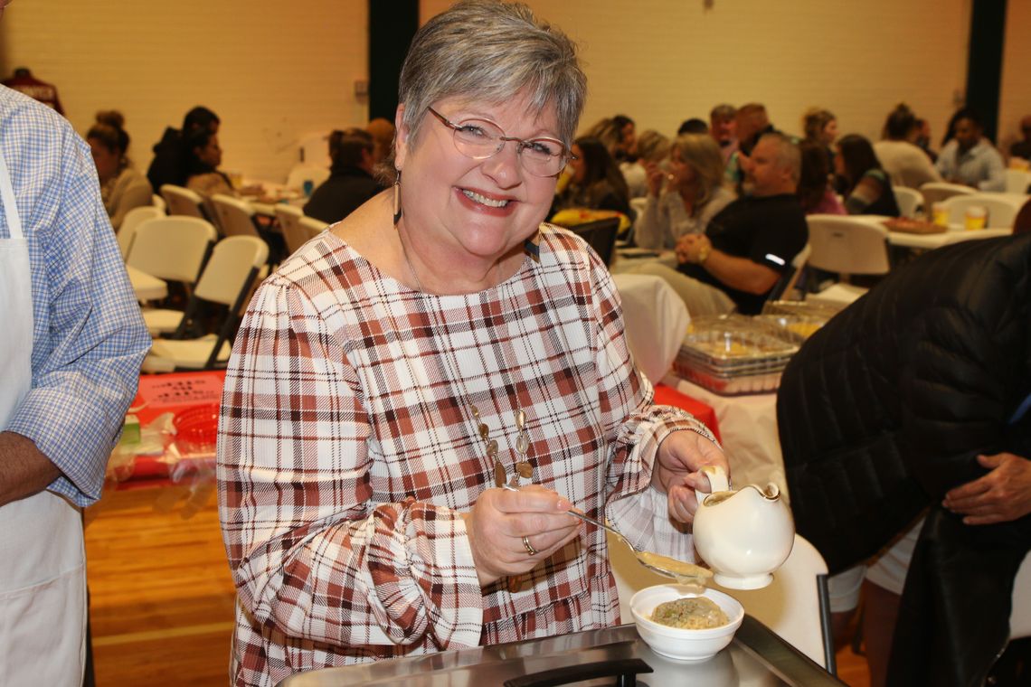 Anita Volek serves up a sample of dressing and gravy at this year’s Food Dudes event, sponsored by the TEE Foundation.   Photo by Tim Crow