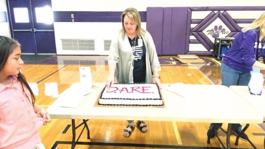 Teacher Cynde Engelke helps with cake for people in attendance of the D.A.R.E. graduation ceremony Jan. 14 in Thrall.