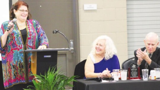 BELOW: Incoming Chamber Board President Cheryl Webster (standing) gets a laugh out of Diana Phillips during the annual chamber awards banquet.