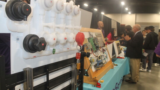  Carl Braun, Workforce Solutions Rural Capital Area business services manager, talks with people at the EMD Electronics table during the Trades Day Career Fair at the Williamson County Expo Center in Taylor March 2.