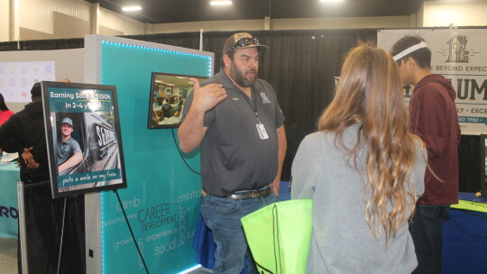 Scott Butler talks with students at the S&D Plumbing table at the Greater Taylor Chamber of Commerce Trades Day career fair at the Williamson County Expo Center in Taylor March 2.